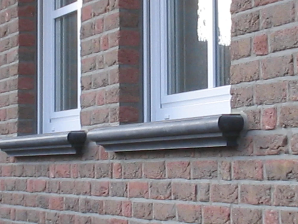 Zwei Fenster mit profilierten Beton-Fensterbänken mit seitlichen Endstücken