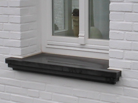 Fensterbank aus Beton Modell 004/800 an weißer Putzfassade Dunkle Beton-Fensterbank Modell 004/800 unter weißem Fenster in weiß gestrichener Fassade